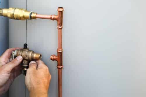 Plombier La-Roche-sur-Yon - Un plombier installant un ballon d'eau chaude électrique.