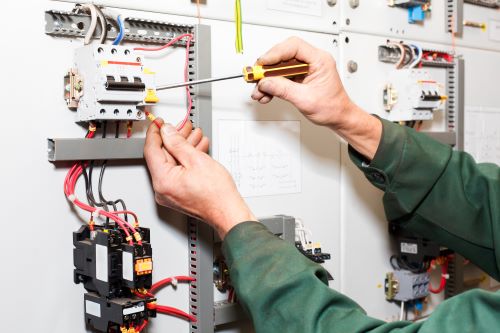 Électricien Rennes - Un électricien travaille sur un tableau électrique.