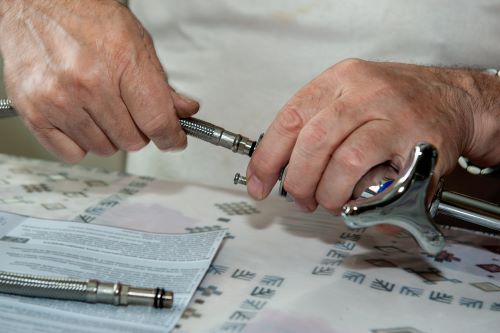 Plombier Caluire-et-Cuire - Un artisan installe un robinet.