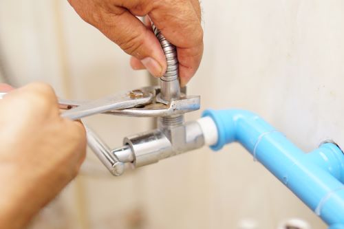 plombier Ermont - un artisan répare un robinet