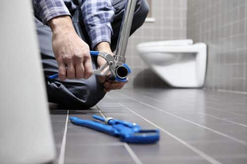 plombier Goussainville - un artisan installe un robinet dans une salle de bains