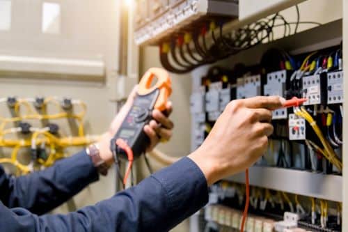 Électricien Quimper - Un artisan fait des vérifications sur tableau électrique.