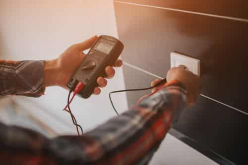 Électricien Saint-Maur-des-Fossés - Un artisan fait des vérifications sur une prise électrique.