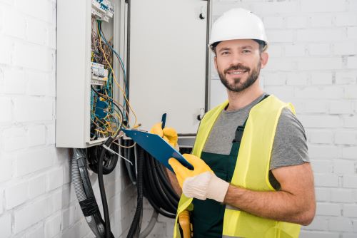 Électricien Vénissieux - Un artisan fait des vérifications sur un tableau électrique.