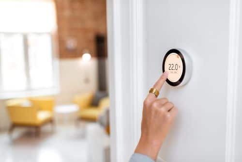 Chauffagiste Narbonne - Une personne règle la température intérieure de son logement.