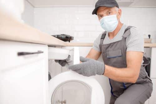 Plombier Décines-Charpieu - Un plombier installe une machine à laver.