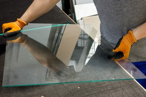 Vitrier Saint-Denis - Un vitrier soulève une vitre.