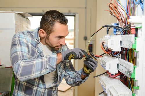 Électricien Villefranche-sur-Saône - Un artisan répare un tableau électrique.