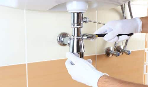 Plombier Nice - Un plombier change le siphon d'un lavabo