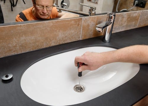 plombier Plaisance-du-Touch - Un plombier débouche un évier.