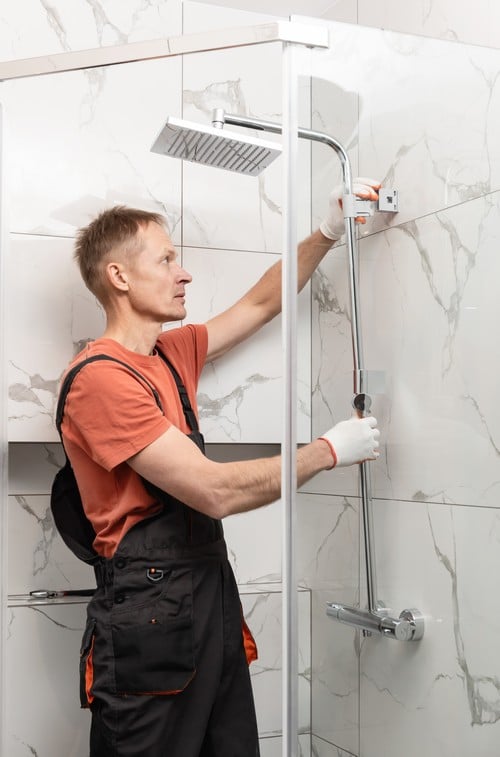 plombier Chevilly-Larue - Un technicien installe une douche.