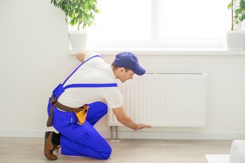 plombier Pertuis - Un plombier installe un radiateur.