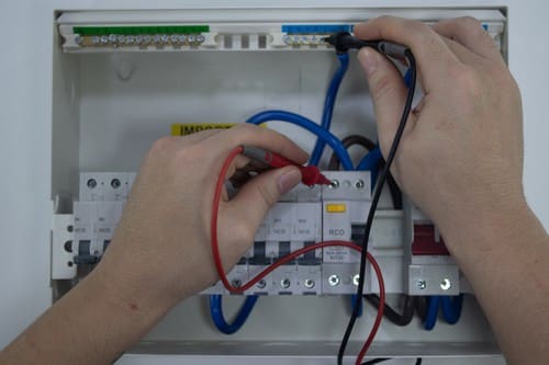 Electricien Paris 11 - les bons artisans - main dans un compteur électrique