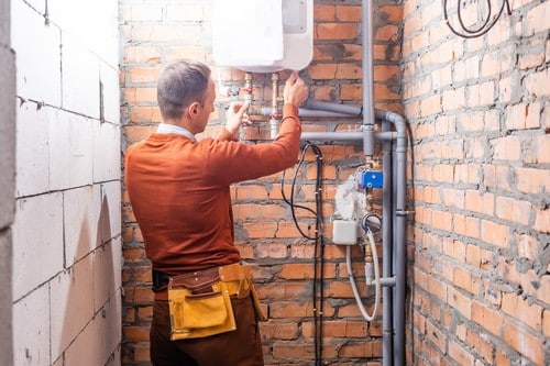 chauffagiste Saint-Lambert - Un chauffagiste qui répare un chauffe-eau