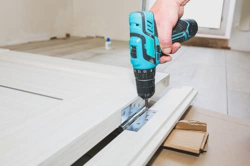 Serrurier Saint-Forget - les bons artisans - construction d'une porte avec perceuse visseuse