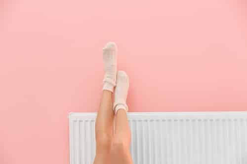 chauffagiste Verrières-le-Buisson - une femme repose ses jambes sur un radiateur