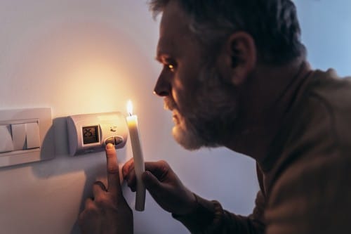 Chauffagiste Yvetot - les bons artisans - homme qui règle son thermostat