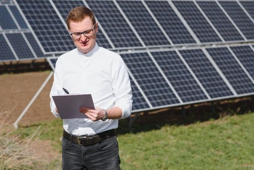 Electricien Arpajon - homme devant des panneaux solaires