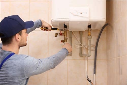 un chauffagiste remplace un groupe de sécurité sur un chauffe-eau