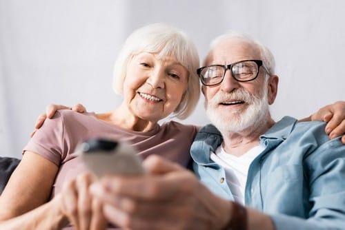 Climatisation Dourdan - un couple qui tient une télécommande pour régler un climatiseur