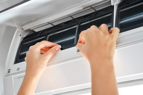 Climatisation Hem - mains d'une personne qui règlent un climatiseur