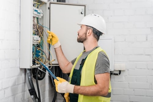 Électricien Cergy - Un électricien fait des vérifications sur un tableau électrique.